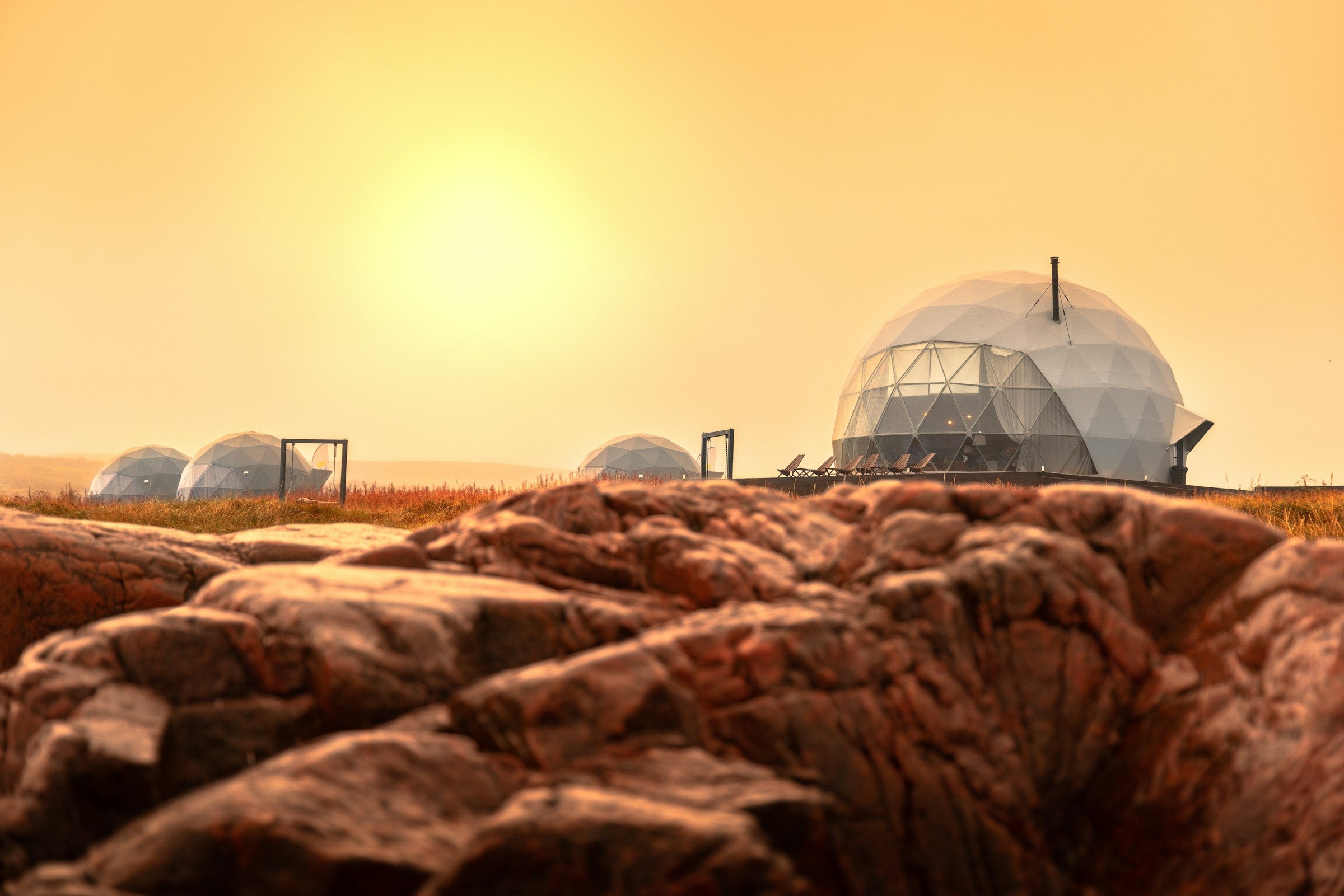 Geodesic glamping domes canada under the warm sun.